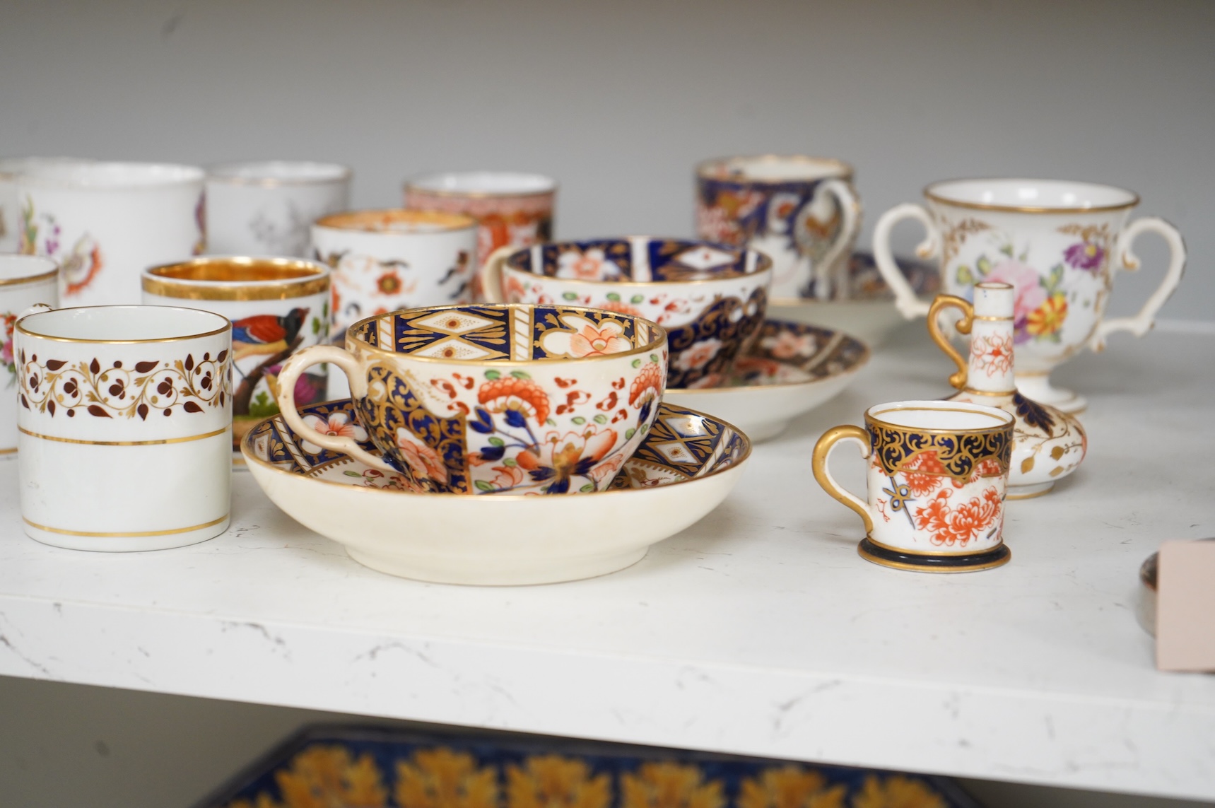A collection of late 18th/19th century English and French porcelain coffee cans, tea cups and vases, some in Imari pattern